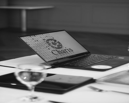 A clean glass of pure clear natural water sitting on a table next to an office laptop morning setup
